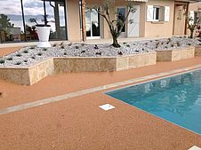 création de jardinière en travertin autour d'une plage de piscine en résine ou résimarbre